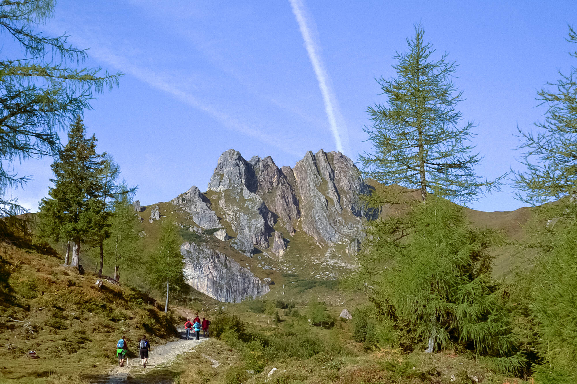 Mehrere Personen wandern zu einer Felsformation.