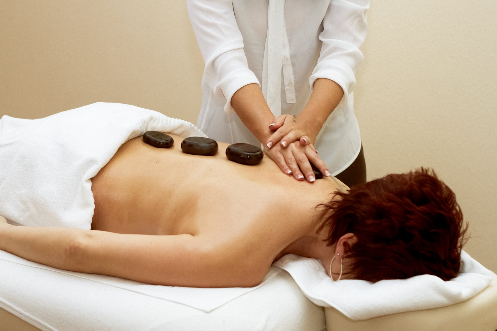 Eine Frau lässt sich bei einer Hot-Stone-Massage verwöhnen.